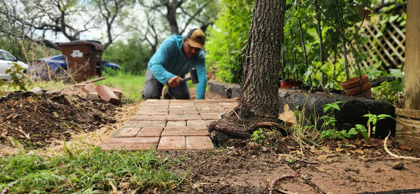 Team member restoring a brick garden patio